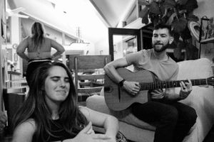 Musicians perform an acoustic song during a casual home gathering.