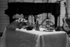 A formal table setting with candles and glasses in black and white.