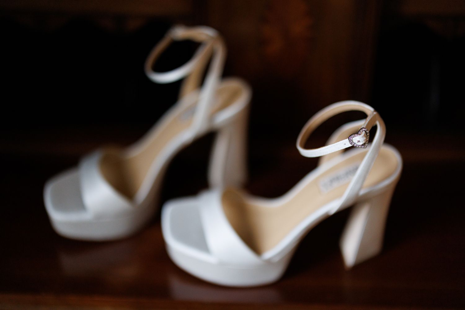 White platform wedding sandals with ankle straps photographed with soft focus.