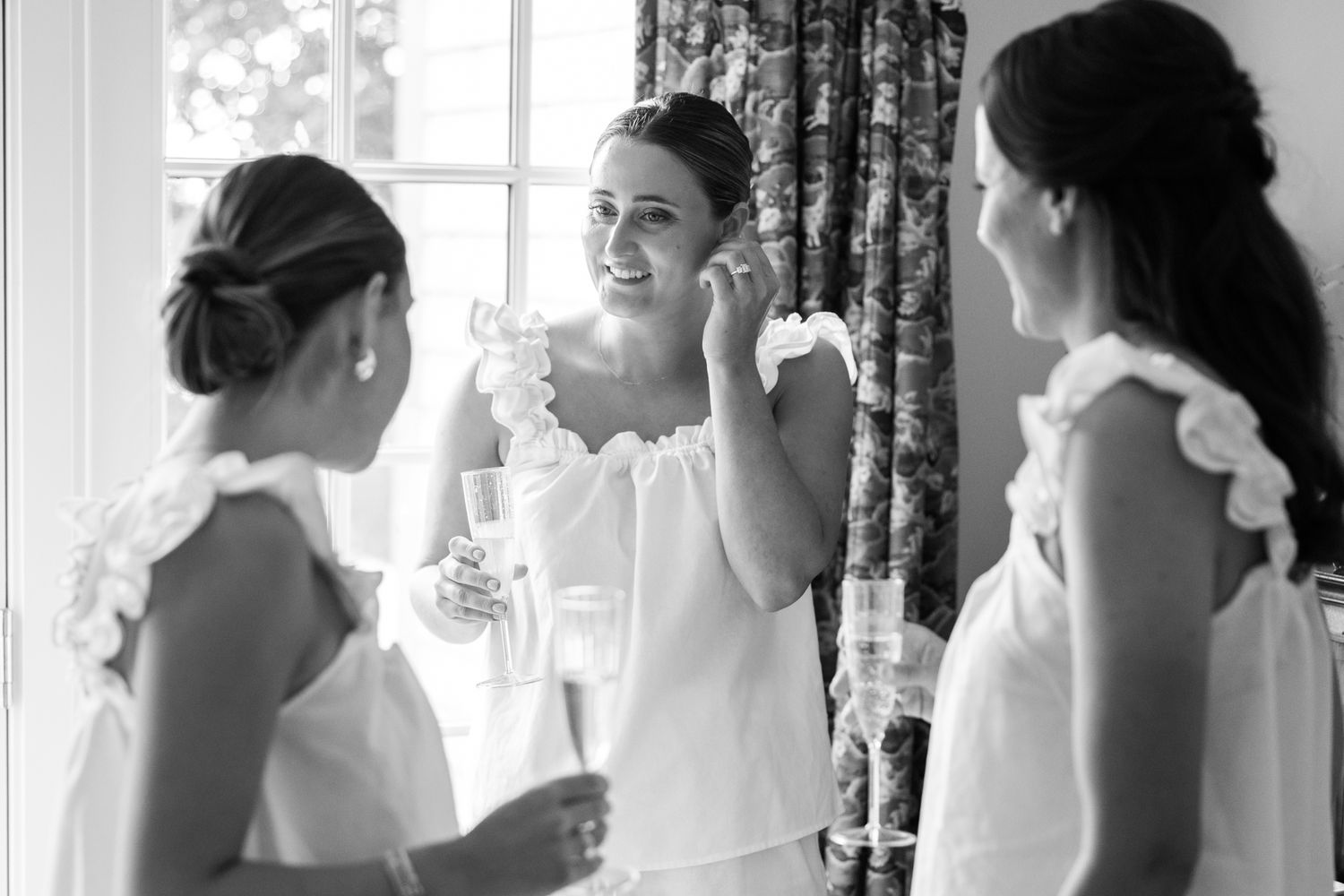 Black and white photo of bridesmaids getting ready before the wedding ceremony.