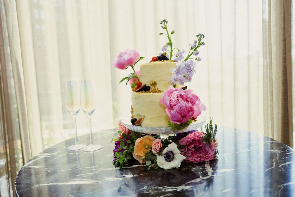 Wedding reception table decorated with delicate spring flowers and white drapery.