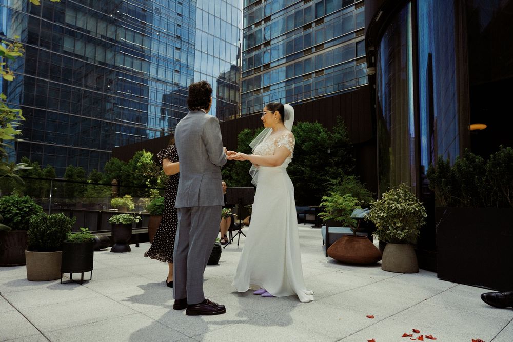A couple shares a romantic moment on a rooftop terrace surrounded by urban architecture.