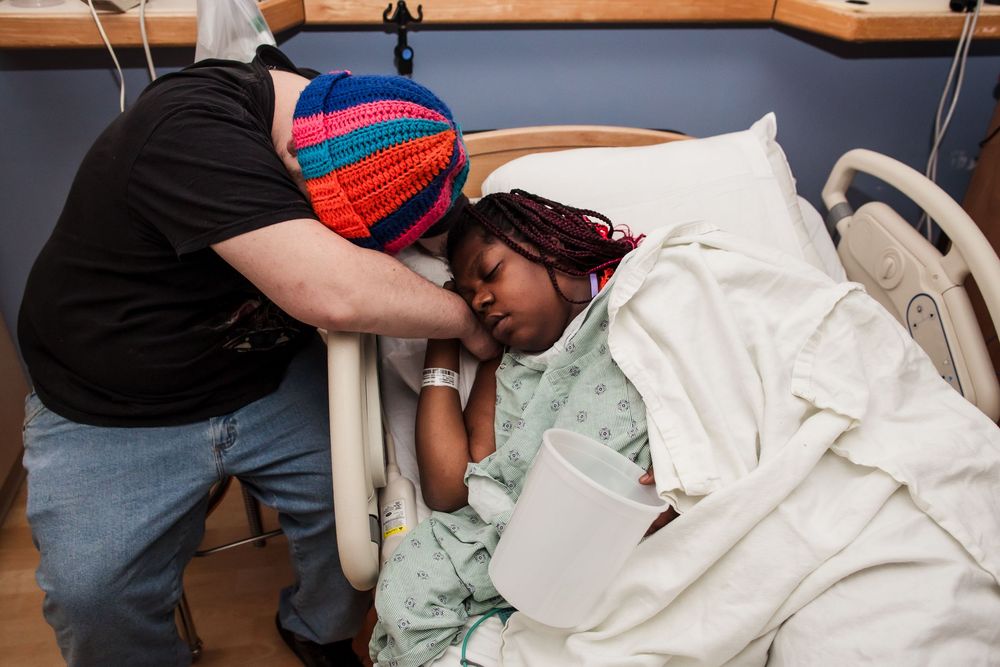 Medical professionals providing care to a patient in a hospital bed.