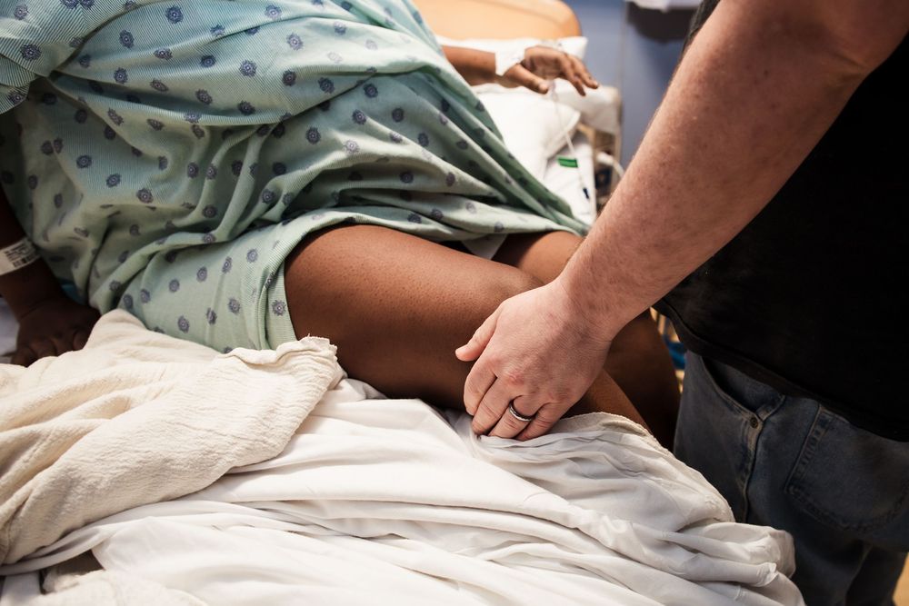 Medical staff providing care to a patient on a hospital bed.