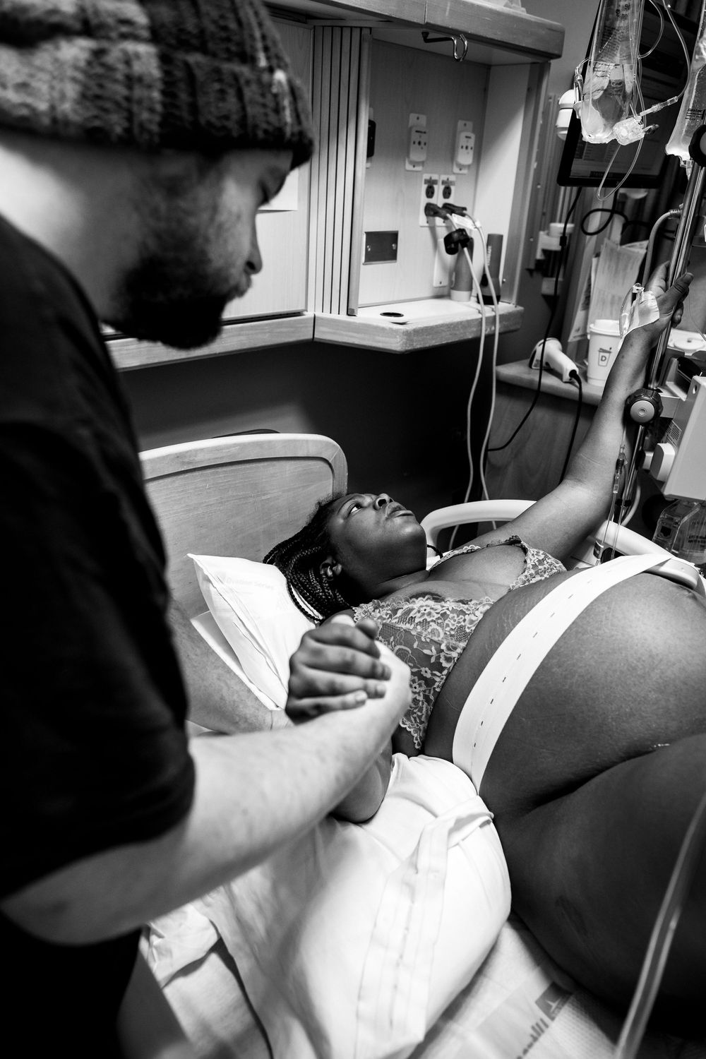 Black and white image of medical professionals providing patient care in a hospital room.