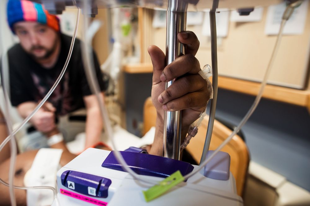 Medical staff in a hospital room attending to a patient during a procedure.