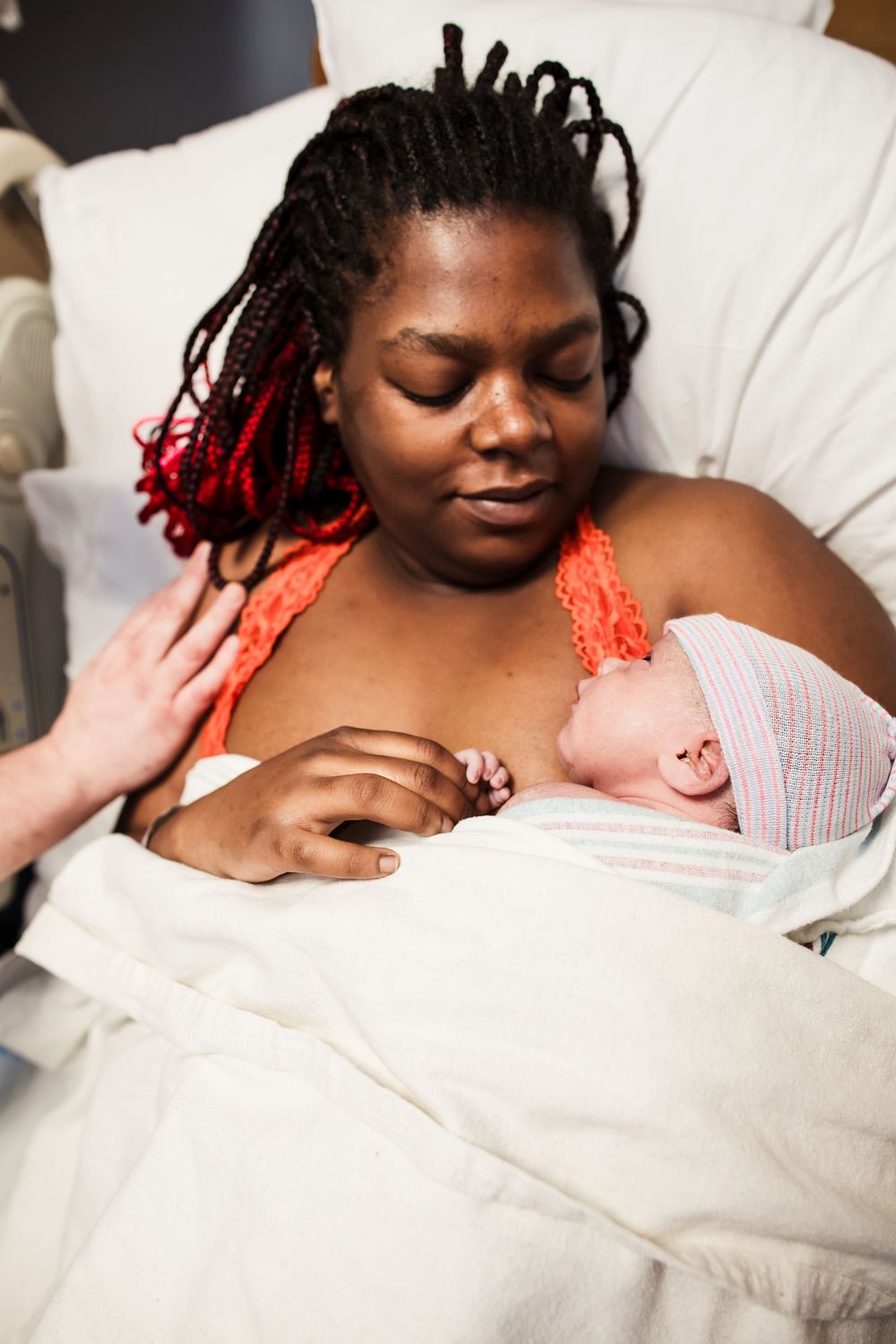 Patient resting peacefully in hospital bed with newborn.
