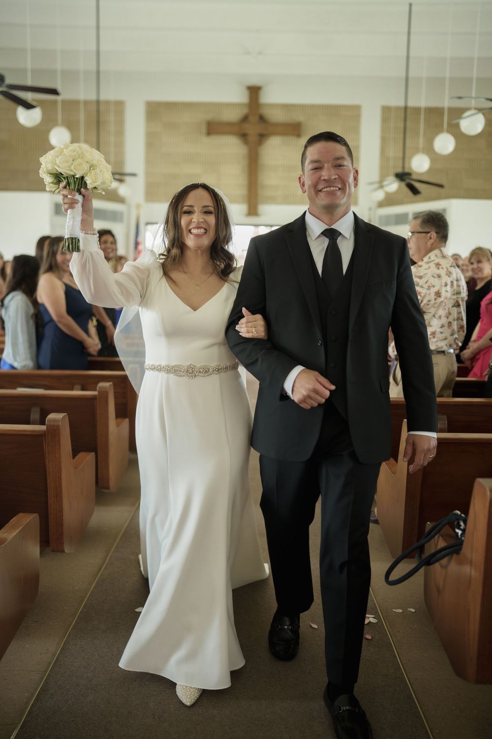 A couple walking down the church aisle after their wedding ceremony.