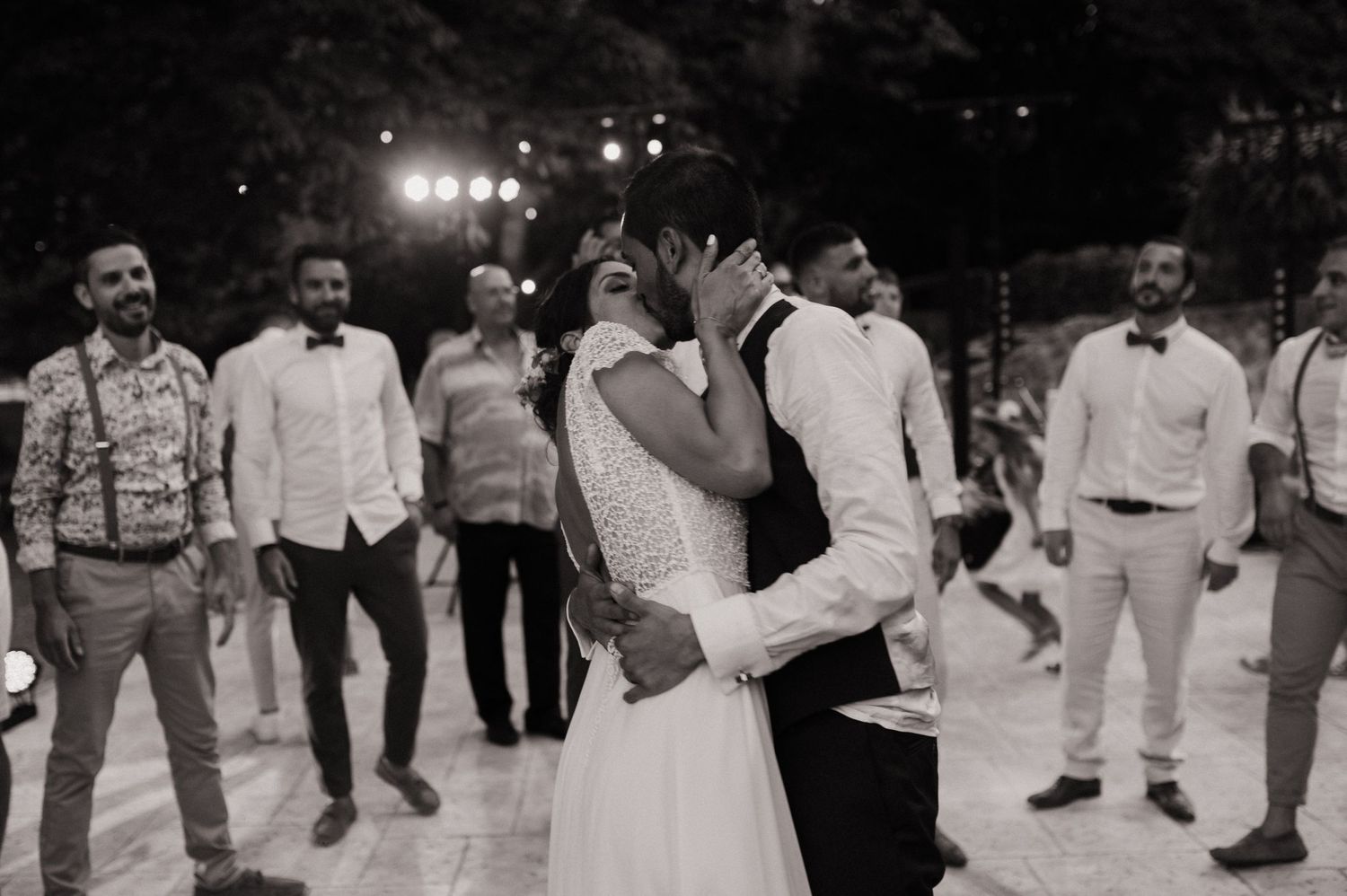 Photographe Domaine des Sources - mariés qui s'embrassent sur le dancefloor pendant que les invités les regardent.