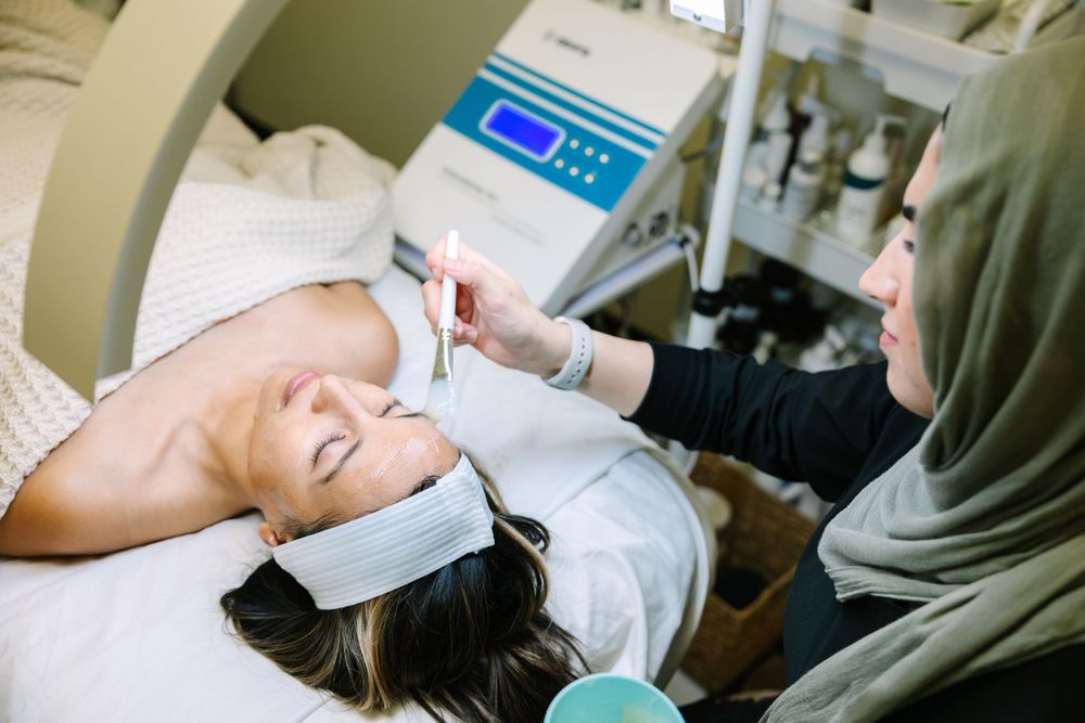 Medical professional performing facial treatment on patient in clinical setting.