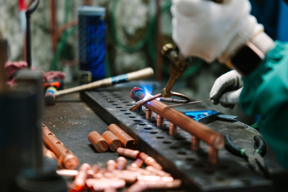 Close-up of assembly work being done with tools and copper components.