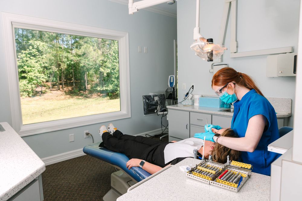 Medical professional performing dental procedure in modern office with window view.