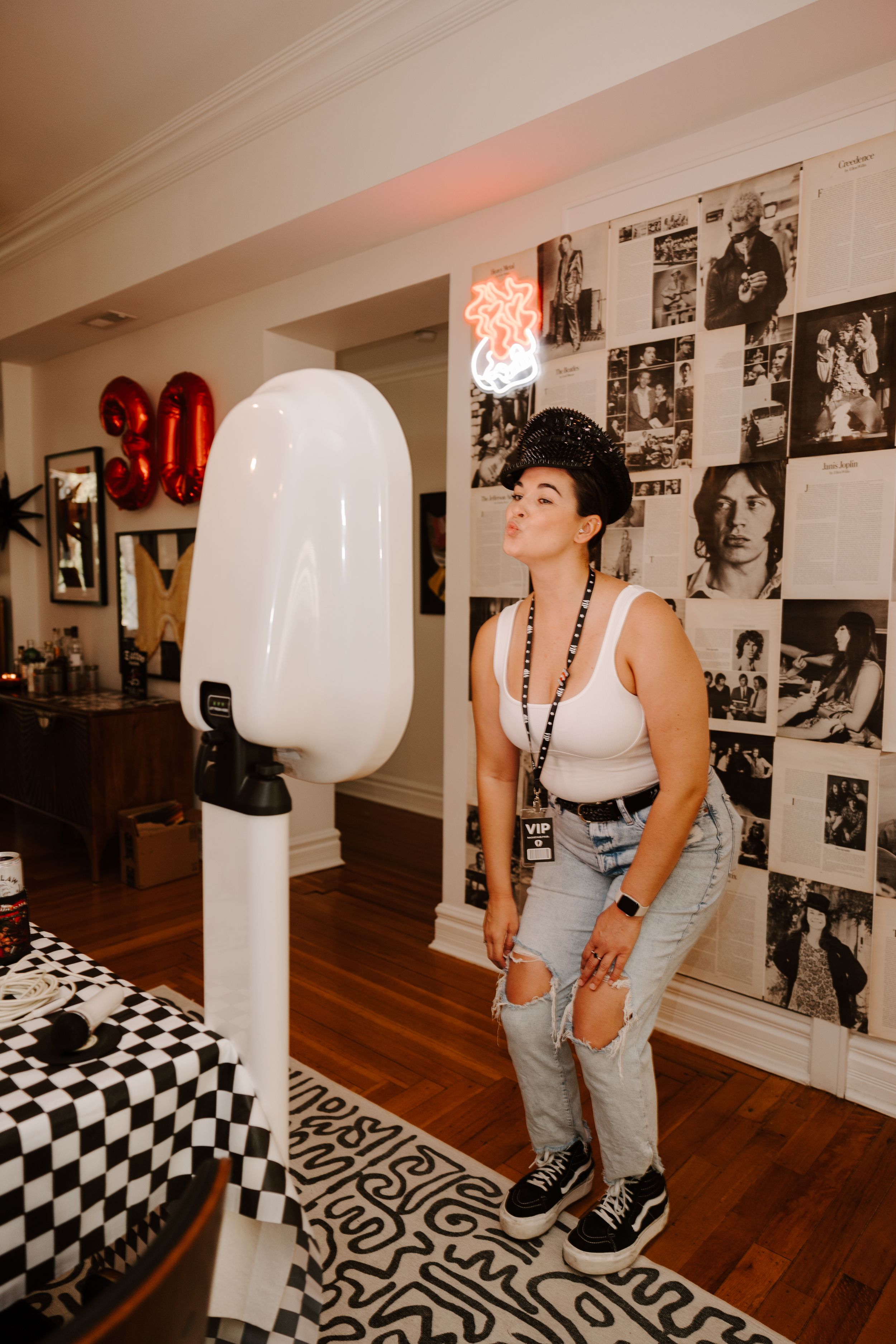Interior party scene with retro wall decor and large white modern art installation.