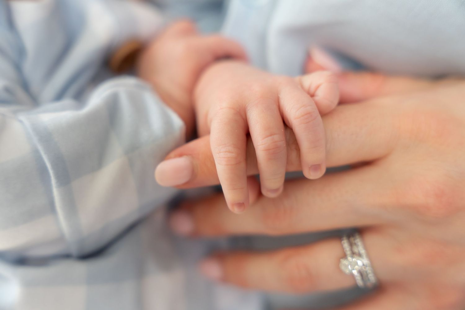 Closeup of two hands gently touching with soft natural light filtering through.