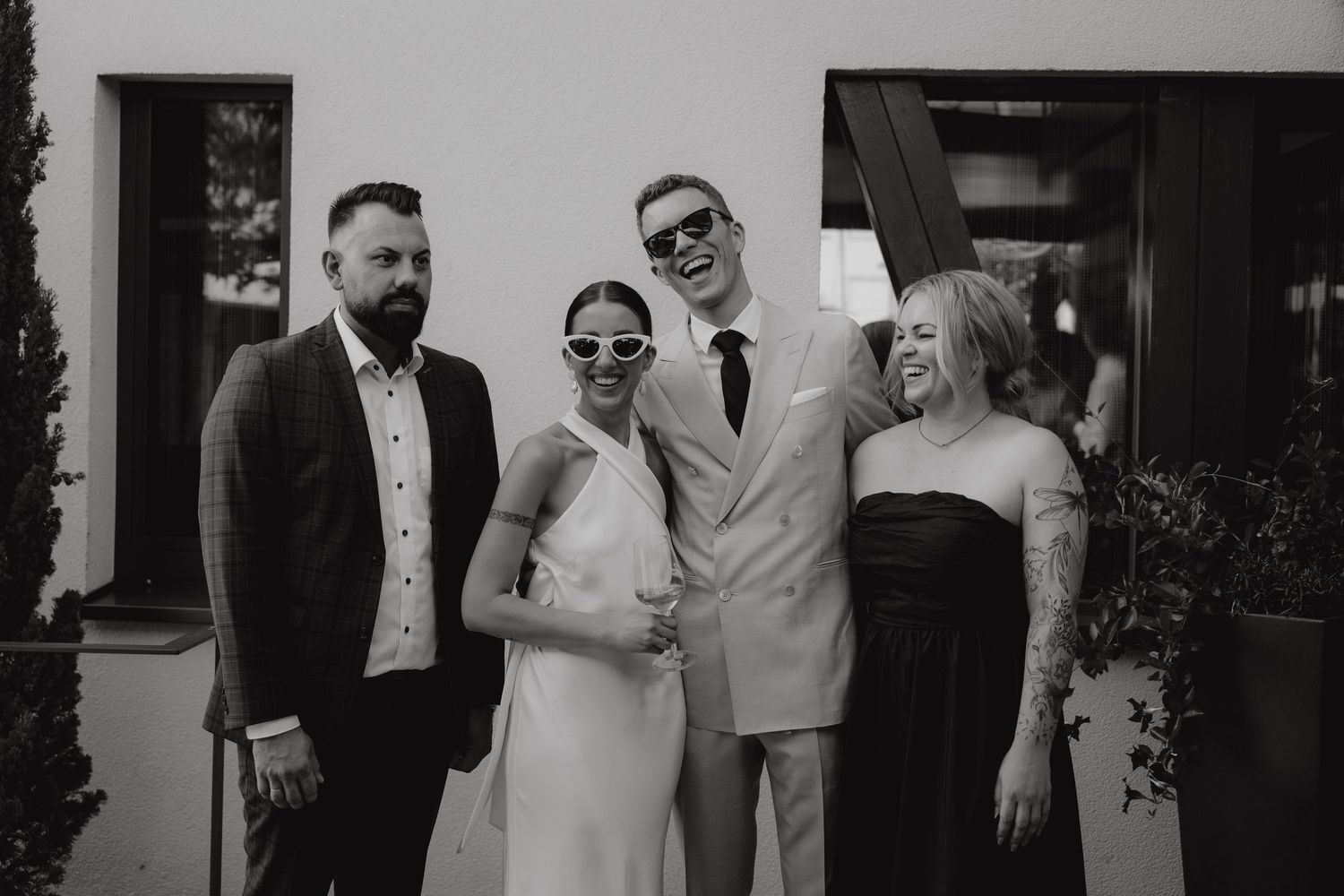 Elegant formal group poses together in black and white at a wedding celebration.