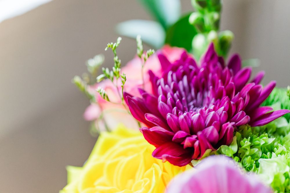 Closeup of vibrant yellow and magenta flowers in a wedding bouquet arrangement.