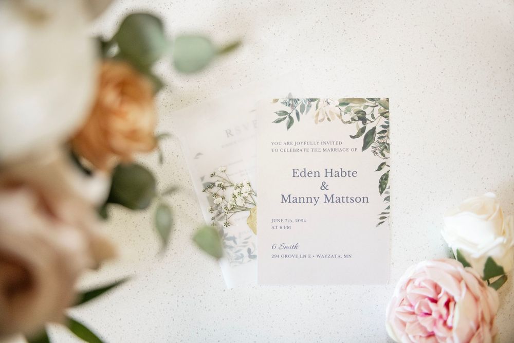 Wedding detail shot of wedding invitation with a floral arrangement. Roses. Natural, bright, warm and clean image. Soft, romantic and simple