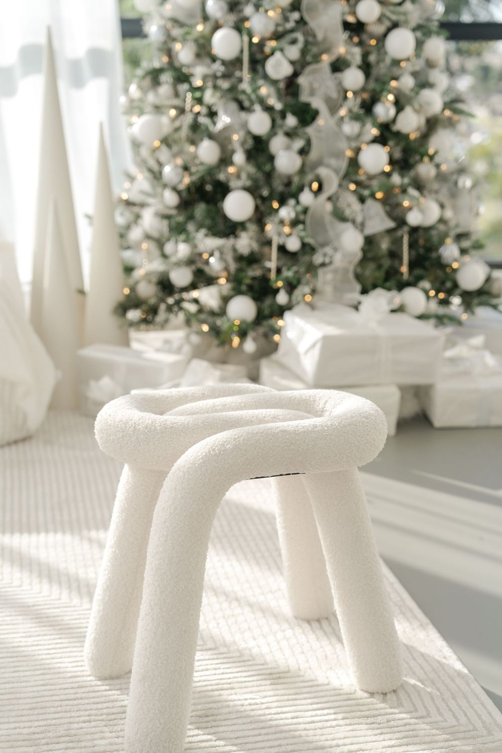 White faux fur Christmas tree skirt with pleated texture creating a snowy base for holiday decorations.