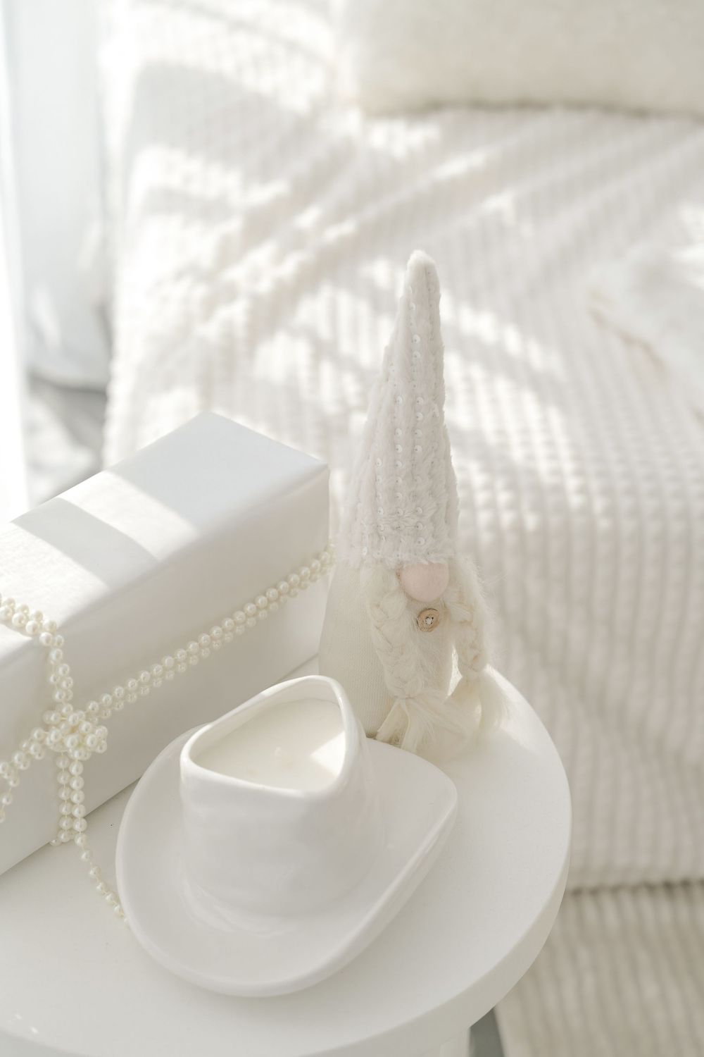 White ceramic tree-shaped decorative pieces arranged on white plates creating a minimalist winter holiday display.