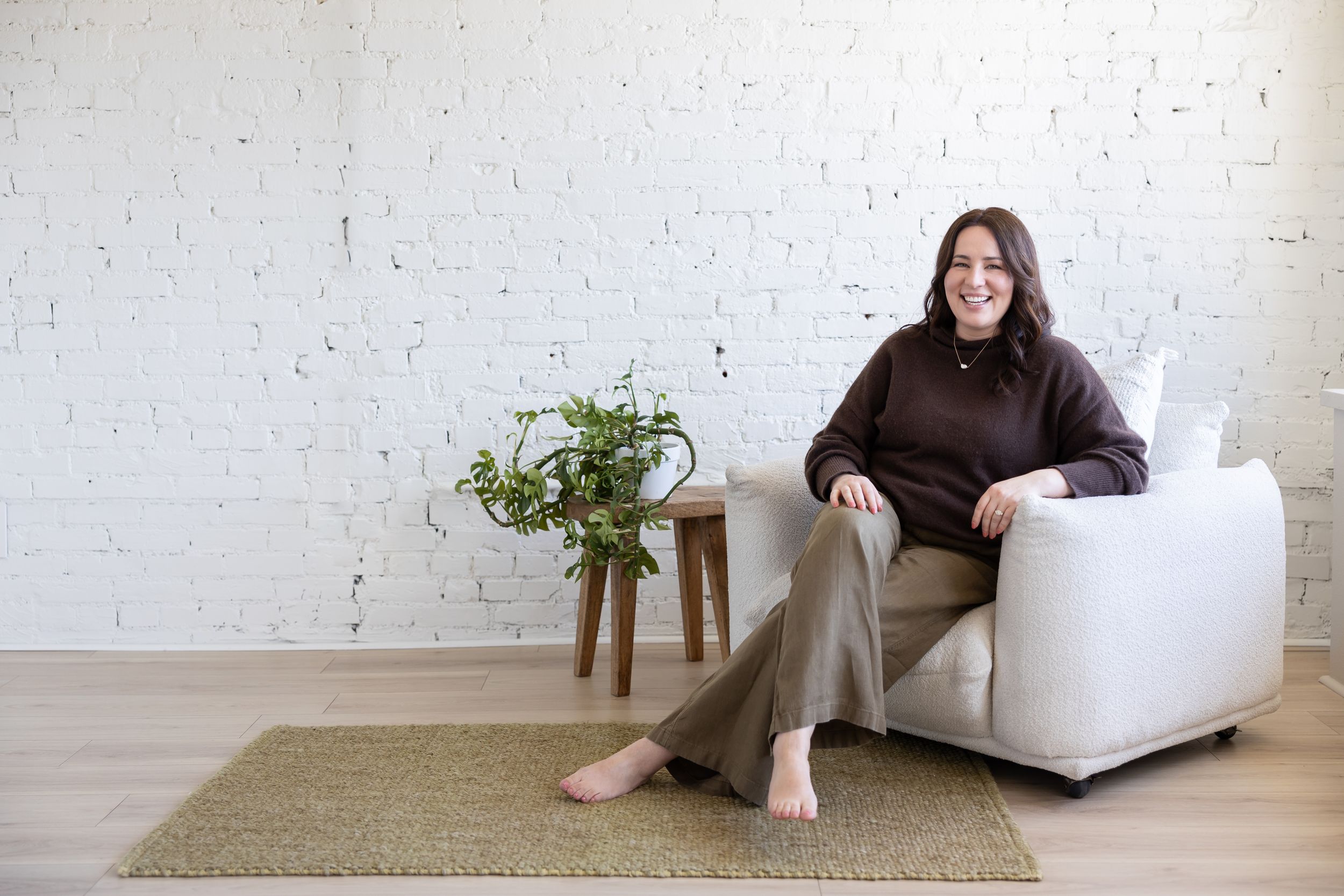 Woman business owner Talks Over Tea Mental Health Therapist in Tacoma, WA personal branding  sitting on couch in white studio