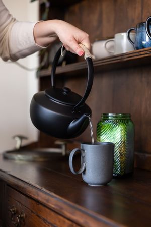Woman business owner Talks Over Tea Mental Health Therapist in Tacoma, WA personal branding  pouring tea to make for client session