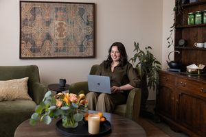 Woman business owner Talks Over Tea Mental Health Therapist in Tacoma, WA personal branding sitting in cozy office chair on laptop zoom call