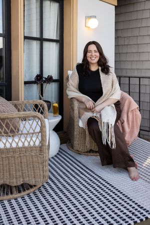 Woman business owner Talks Over Tea Mental Health Therapist in Tacoma, WA personal branding sitting outside on office patio smiling
