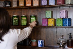 Woman business owner Talks Over Tea Mental Health Therapist in Tacoma, WA personal branding  grabbing tea tin to make for client session