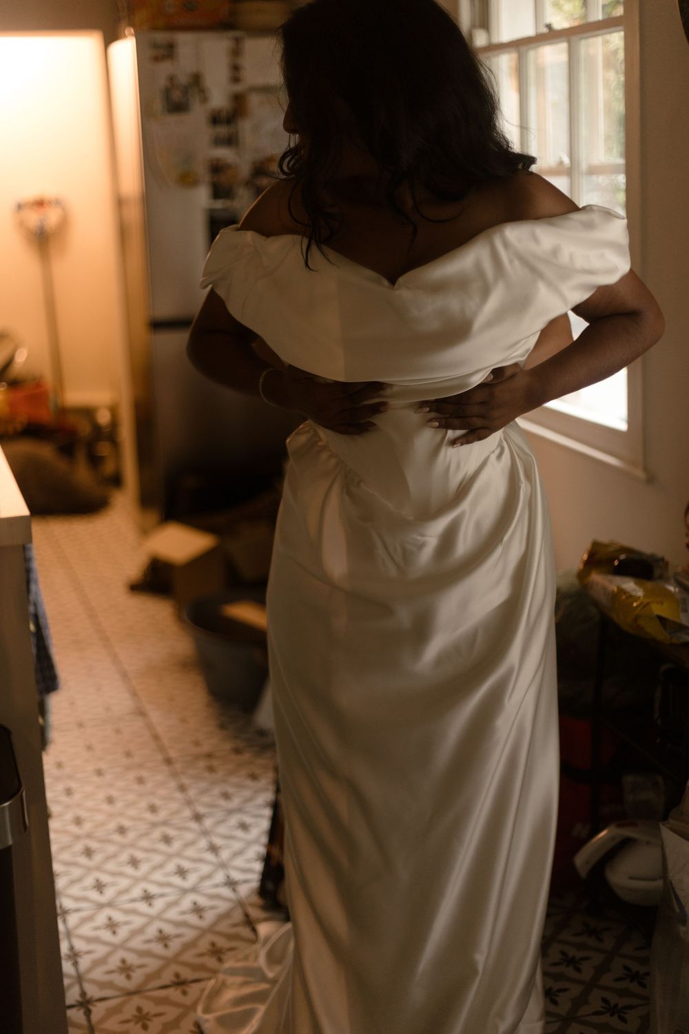 Figure in white dress moves gracefully across geometric patterned floor tiles in warm interior lighting.