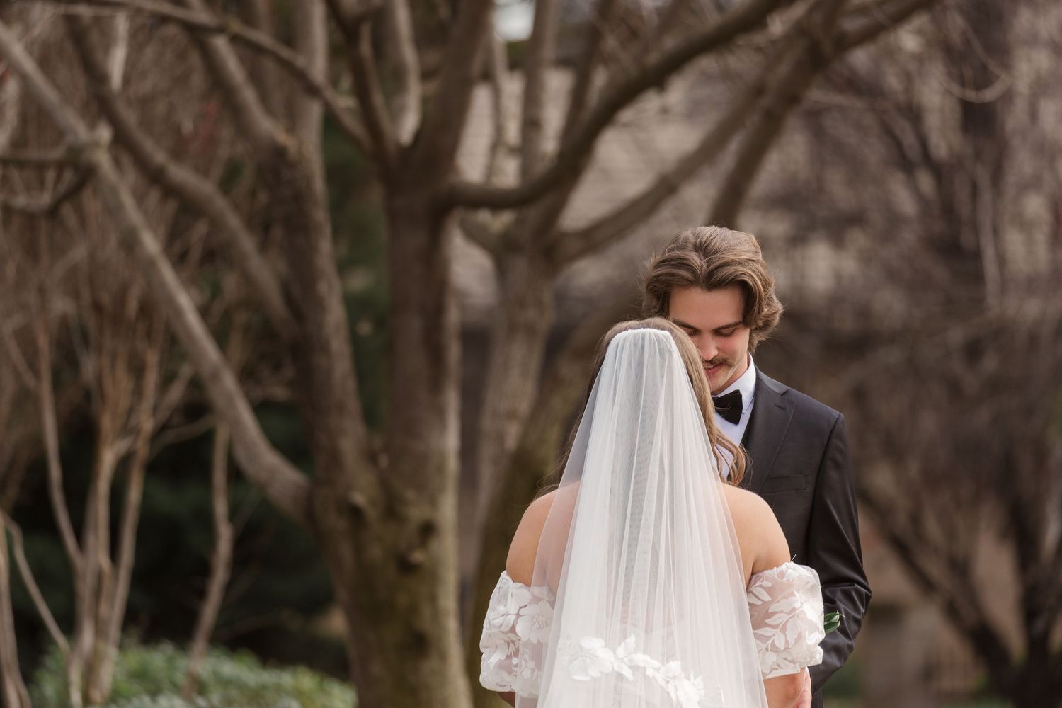 A couple shares their first look moment in a garden setting.