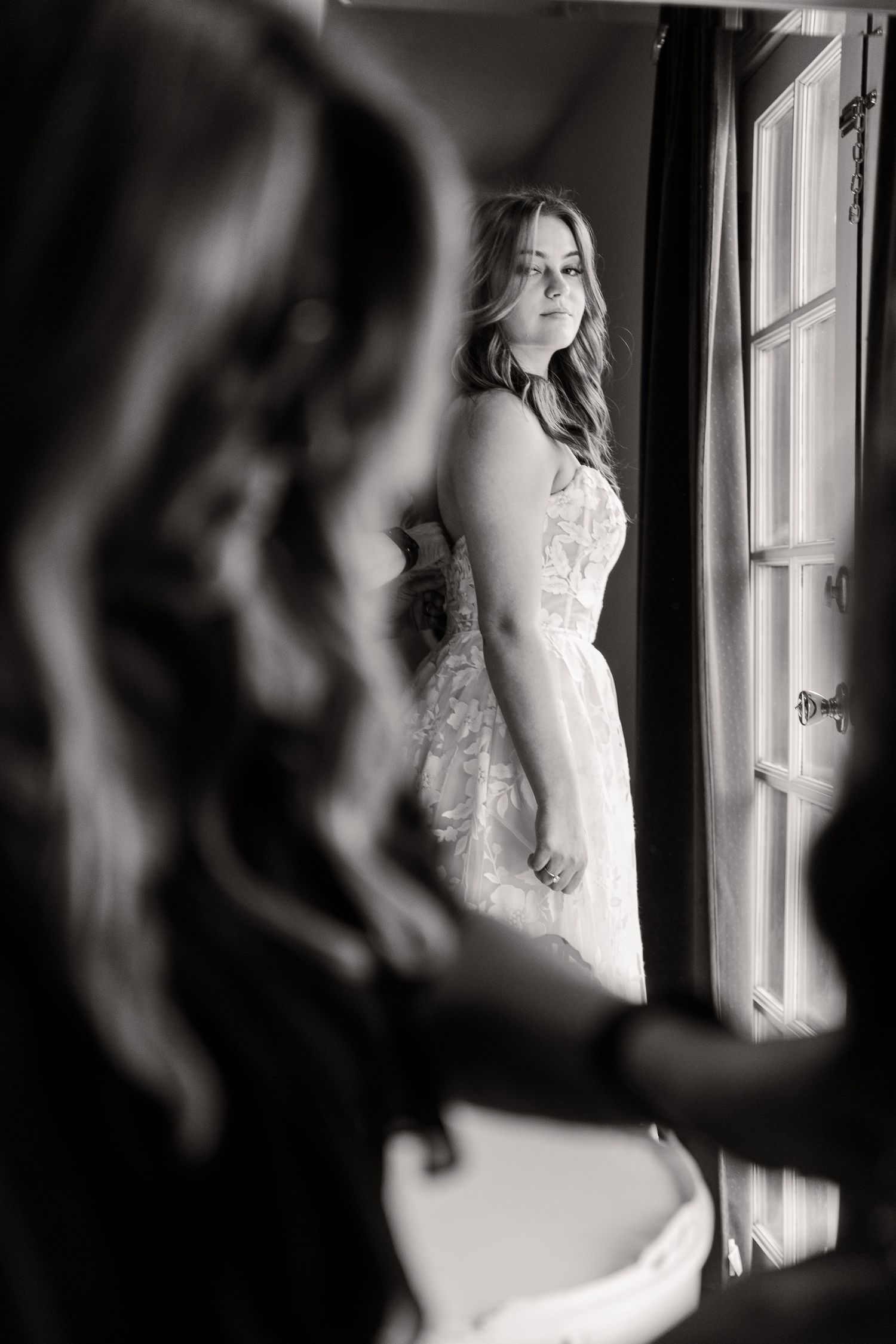 Black and white artistic photos of a bride getting ready by a window.