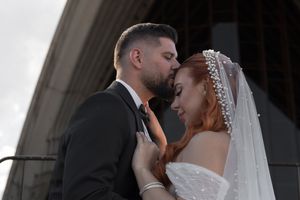 Intimate wedding moment captured in black and white against architectural backdrop.