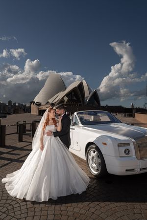 Luxury wedding photoshoot with white Rolls Royce and Sydney Opera House in background.