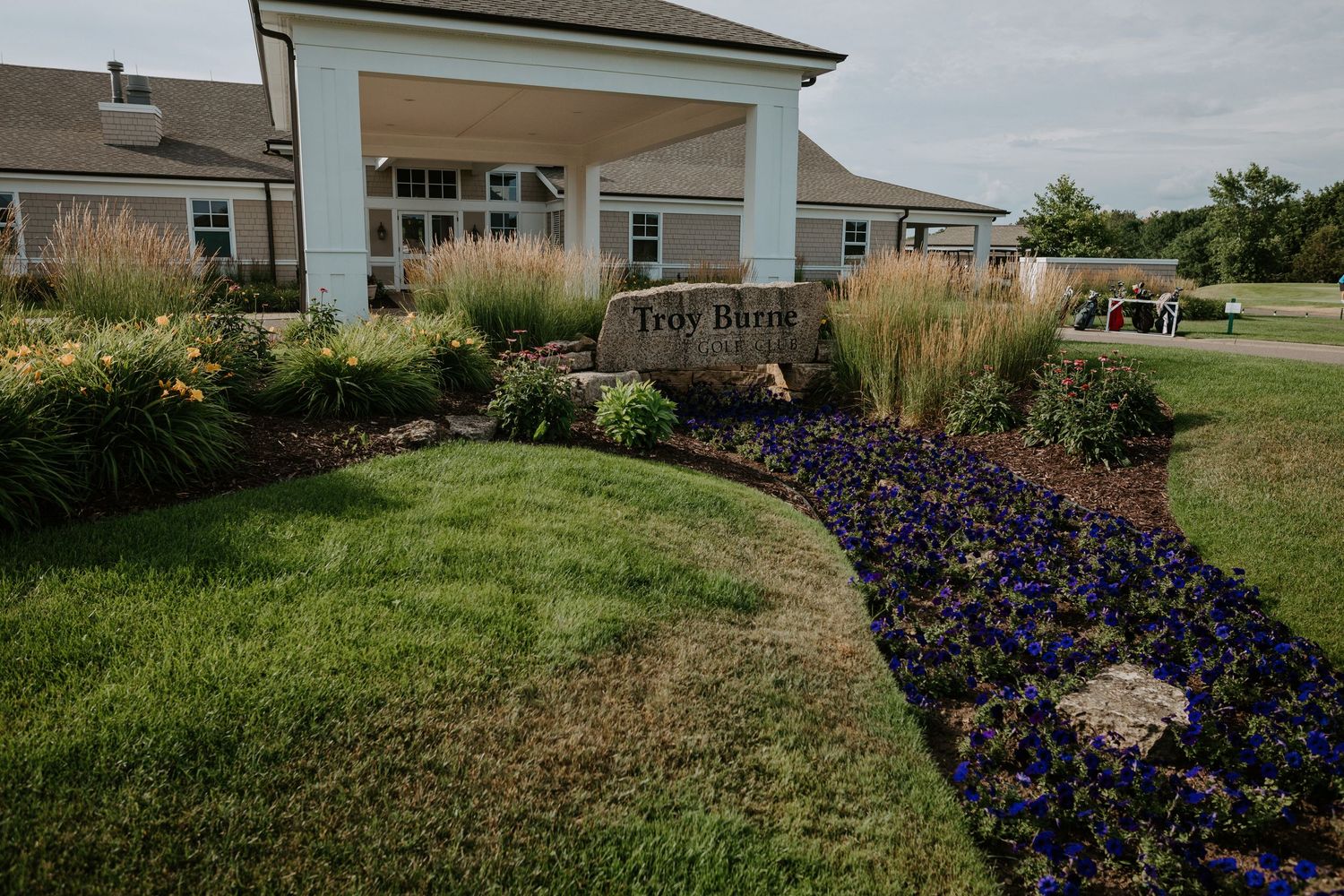 Landscaped entrance to Top O' The Morning golf club with colorful flower beds.