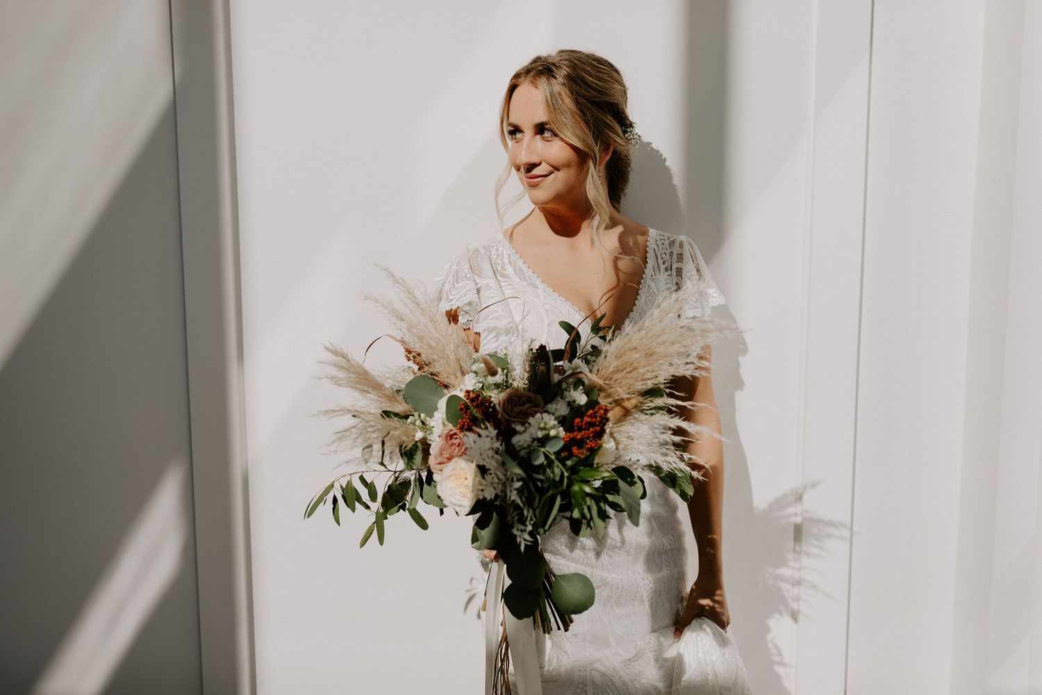 Wedding portrait with elegant bouquet of mixed flowers and greenery.