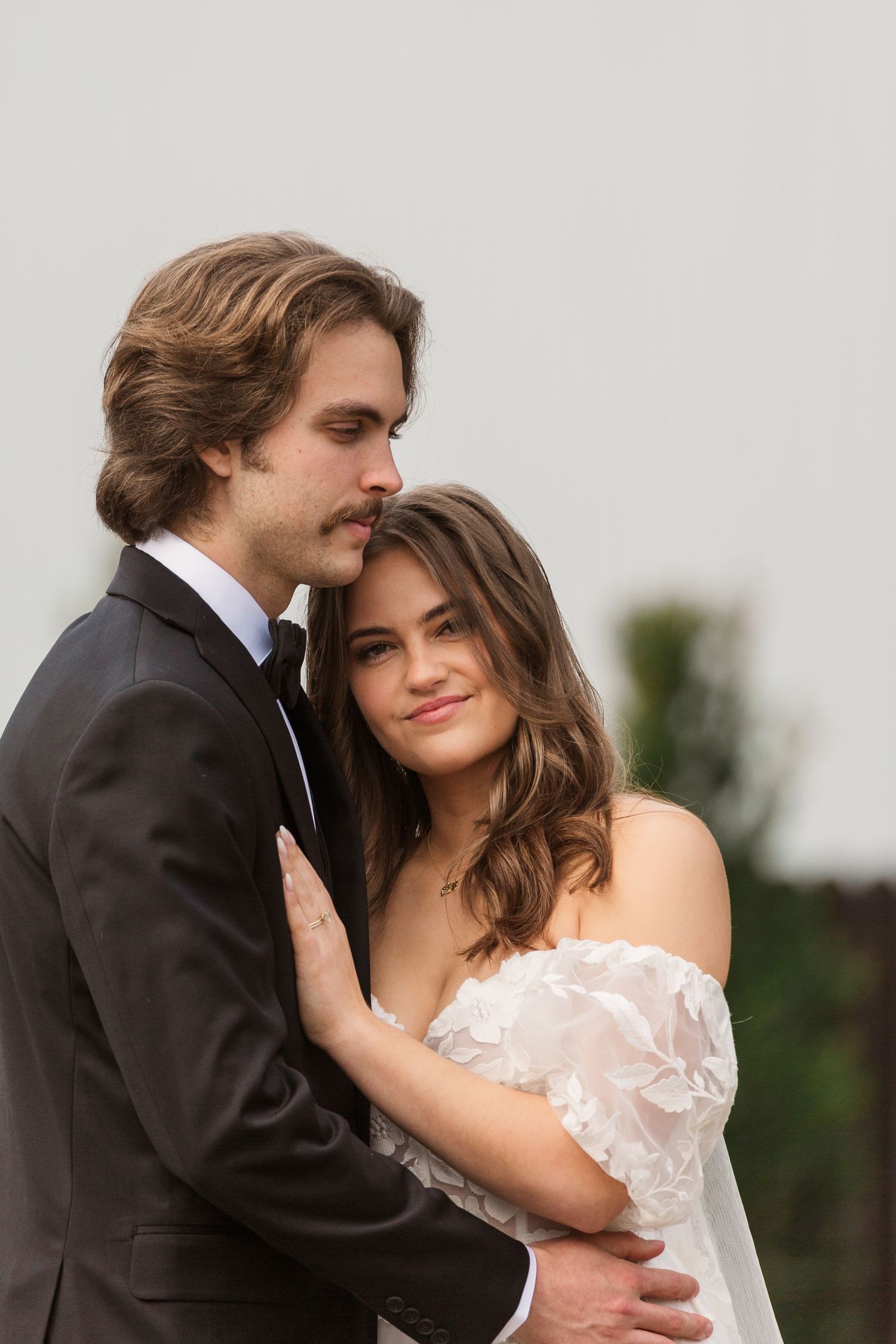 A romantic portrait of a couple in formal attire sharing an intimate moment.