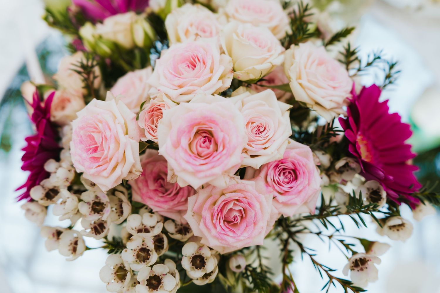 Romantic bouquet of pink roses and white flowers arranged in an elegant wedding centerpiece.