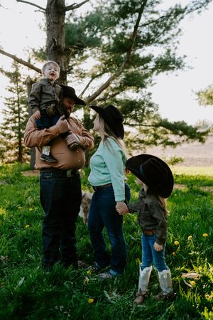 A joyful family moment captured in nature wearing coordinated western outfits.