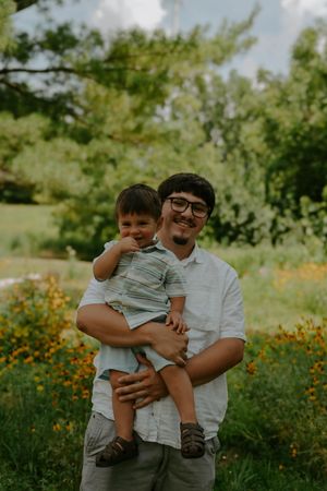 A tender family moment captured in a wildflower field during golden hour.
