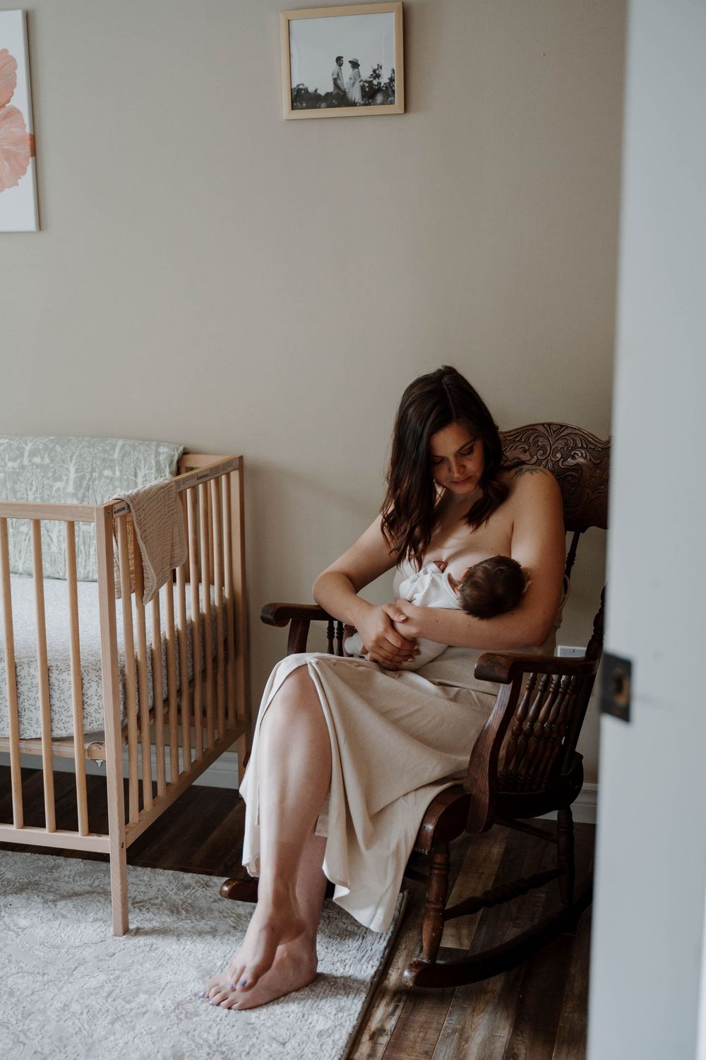 Nursery scene with wooden crib and rocking chair in natural light.