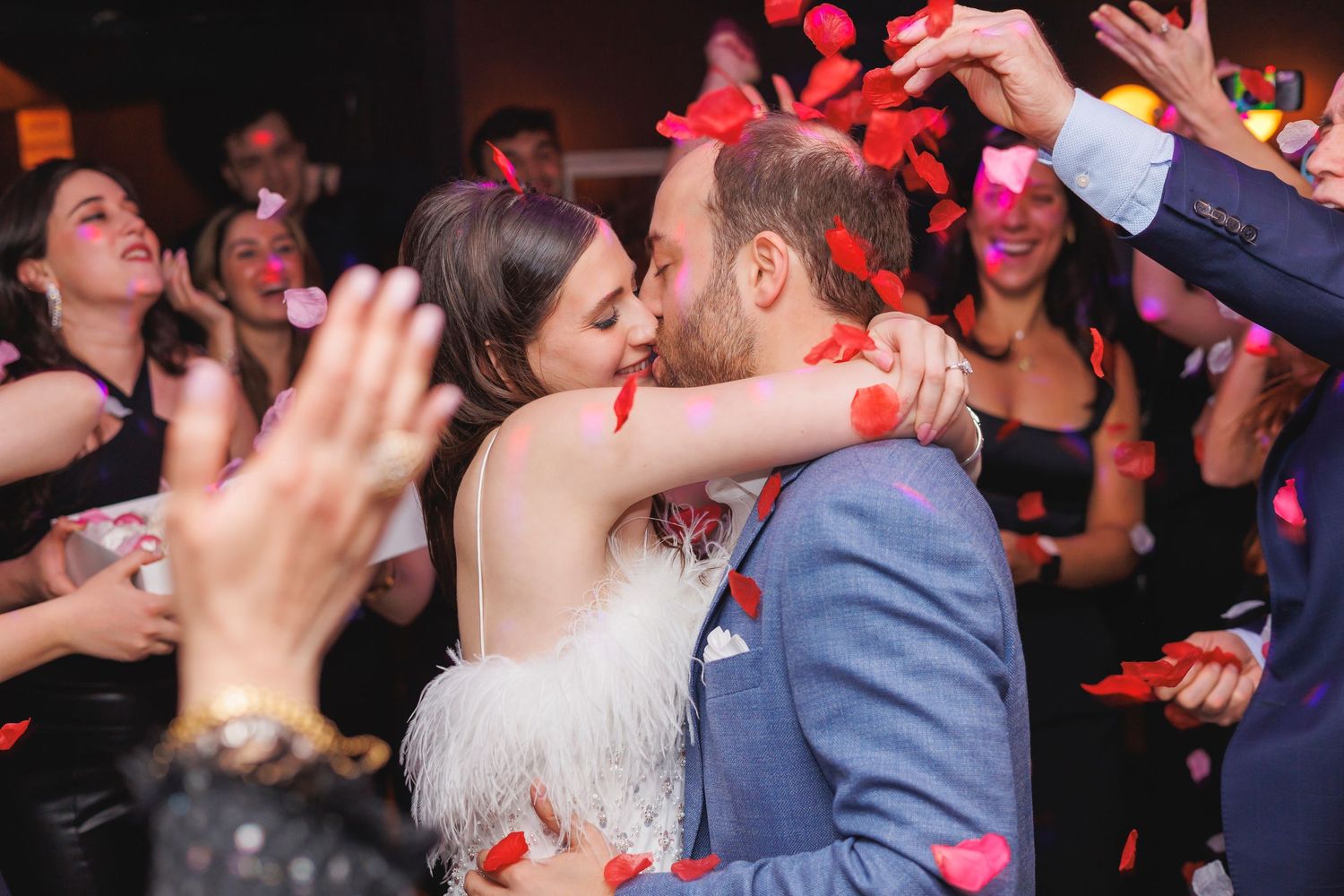 Wedding reception dance party with red lighting and guests celebrating on the dance floor.