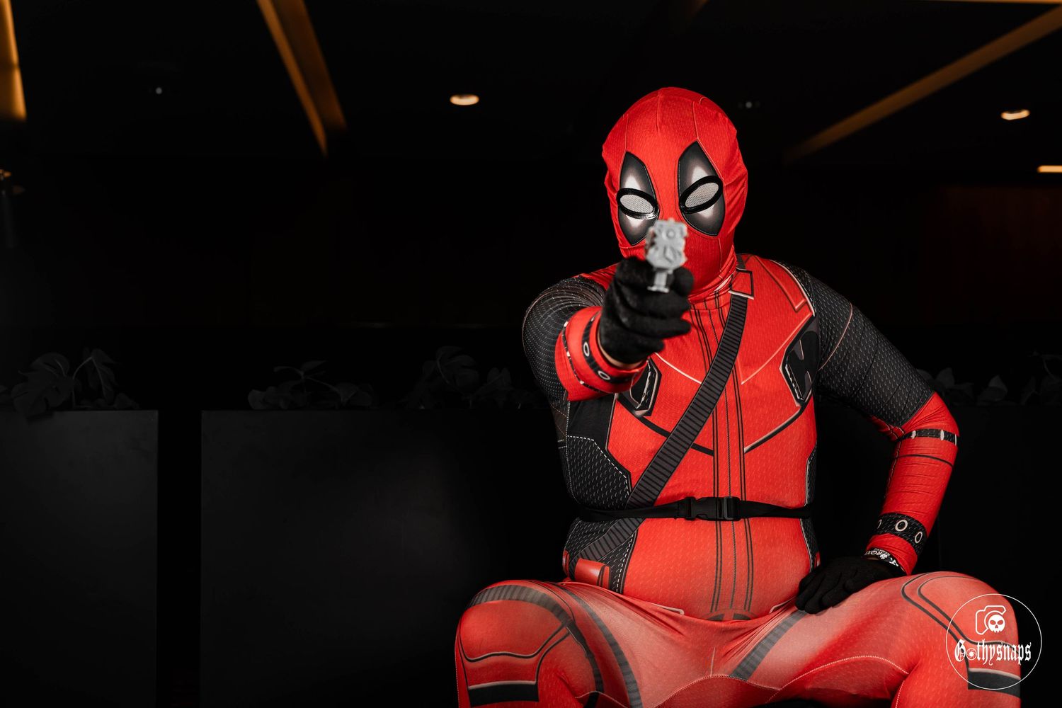 Deadpool Cosplayer pointing his pistol ready to aim and shoot whatever stands in his way.