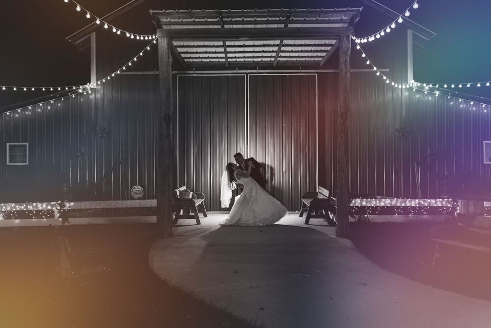 Romantic first dance at wedding reception with string lights and silhouetted couple on empty dance floor.