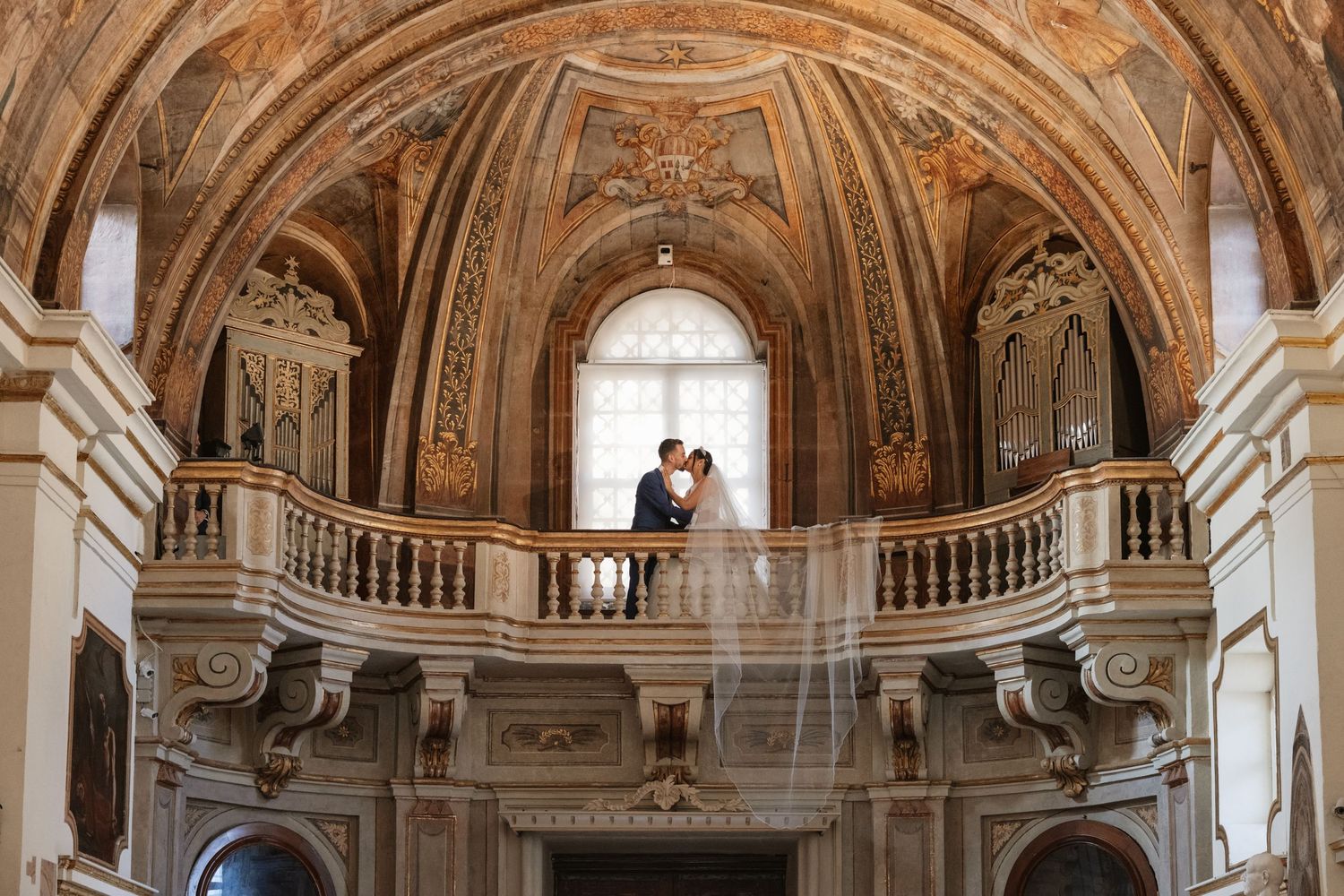 Panoramic view of a luxurious baroque-style hall with painted ceiling and gilded details.