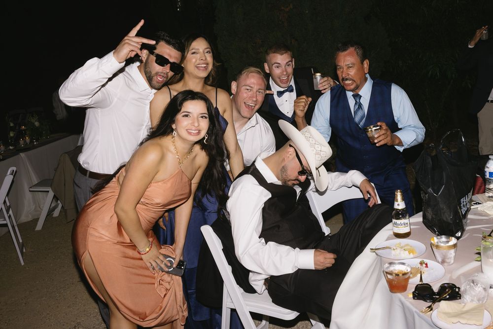 People dance and celebrate together during what appears to be a wedding reception or formal party event.