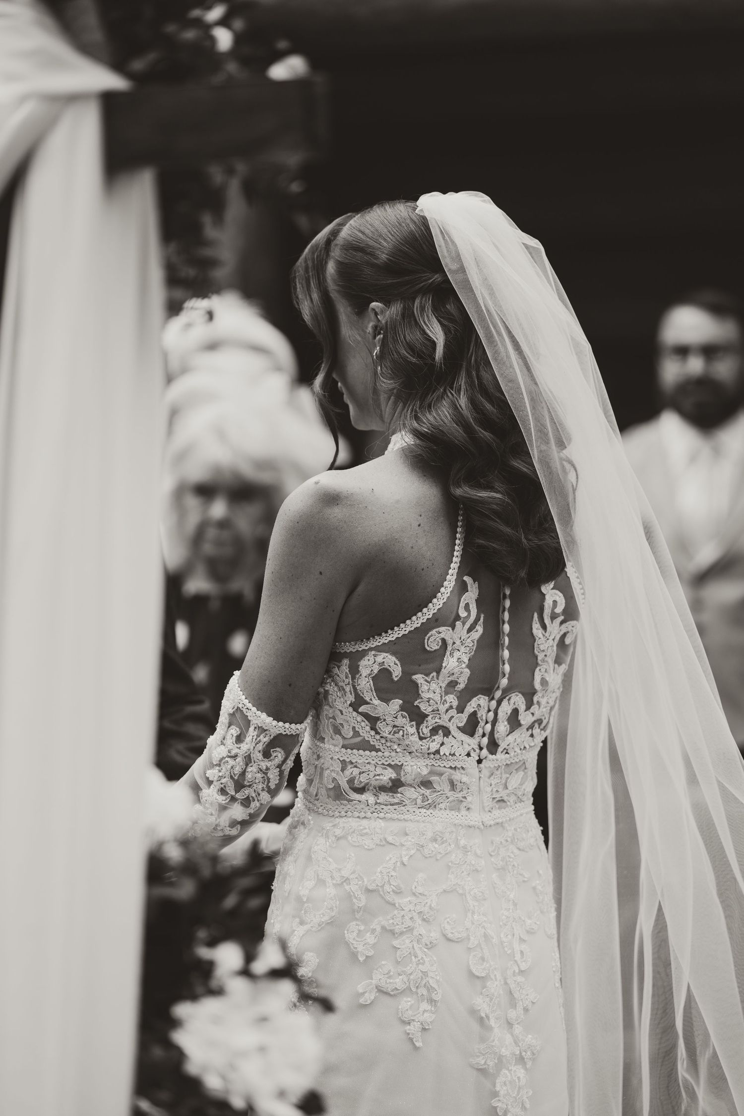 Close-up detail shots showcase intricate lace pattern on back of wedding gown.