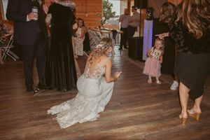 Wedding reception dance party in full swing with guests celebrating on a wooden dance floor.