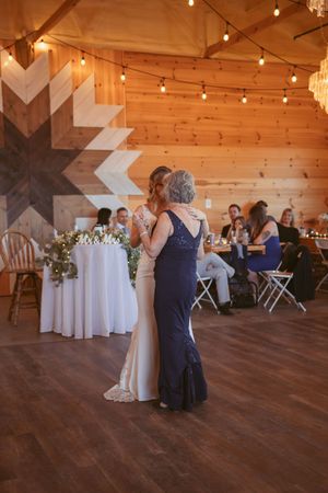 A rustic barn wedding venue decorated with string lights and elegant white tablecloths.