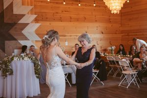 Rustic barn wedding venue with wooden paneled walls and hanging crystal chandeliers.