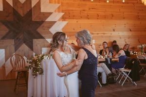 Guests enjoying themselves during a dance at a rustic barn wedding reception with string lights.